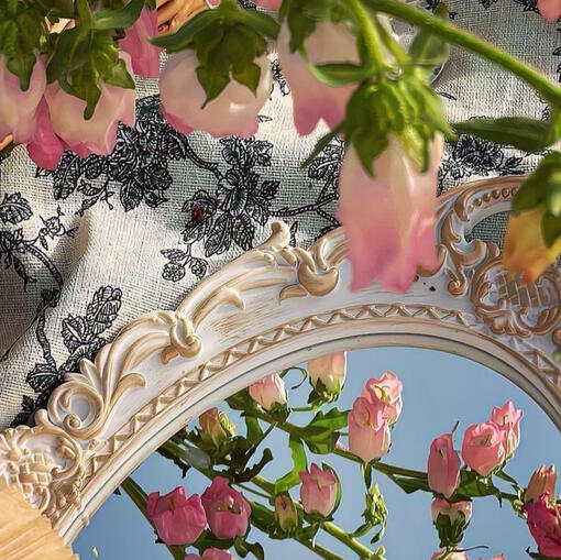 a bundle of pink flowers is dangling above a fancy table